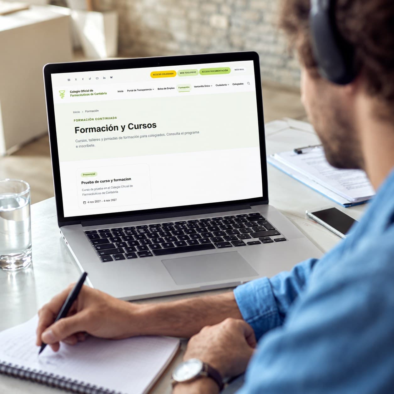 Persona consultando la página de Formación y Cursos del Colegio en su portátil